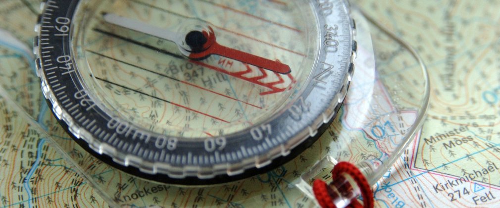 Close up of an orienteering compass on top of a map