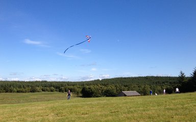 Someone flying a kite in a open field at Gisburn 