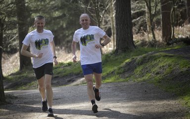 Two men running in the forest