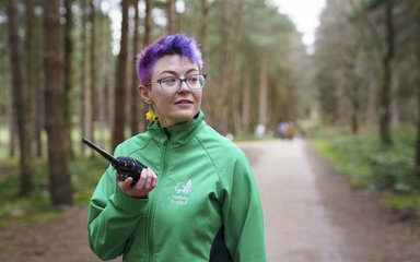 woman with short purple hair working in a forest